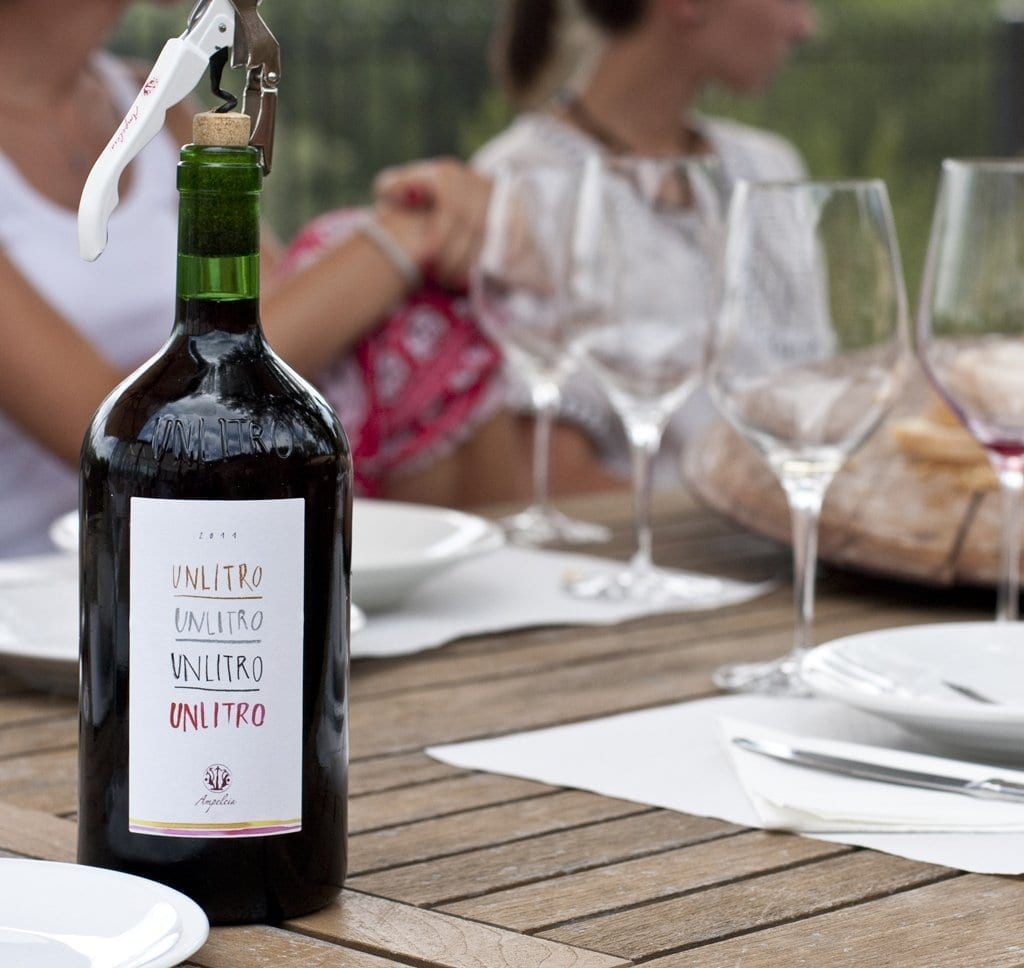 botella de Unlitro con copas de vino de fondo